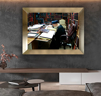 תמונה של הרב עובדיה יוסף יושב בחדר עם ספרי תורה ומתפלל