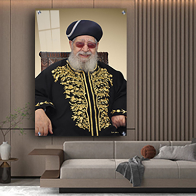 תמונה של הרב עובדיה יוסף יושב על כסא ומחייך